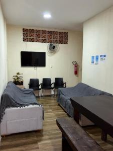 カボ・フリオにあるHospedaria Casa Novaのベッド2台と薄型テレビ付きの部屋