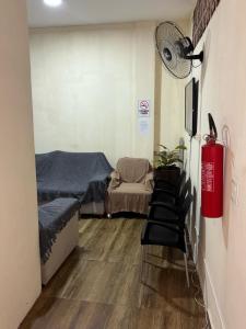 カボ・フリオにあるHospedaria Casa Novaのベッド、ファン、椅子が備わる客室です。
