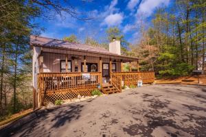 una casa con un gran porche y un camino de entrada en Fox's Den, Hot Tub, FREE Attraction tickets for each paid day, Arcade Game, WIFI!!!, en Pigeon Forge