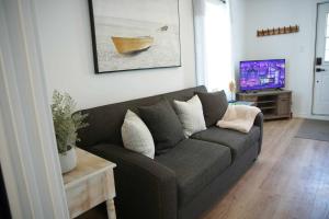 a living room with a couch and a tv at L'Oasis de Nancy in Rouyn-Noranda