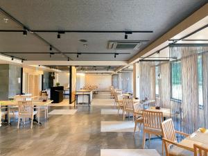 a dining room with tables and chairs and windows at Diamond Hakone Society in Hakone