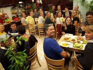 Un gruppo di persone sedute a tavola che mangiano di Dalat Peace Backpackers Hostel a Da Lat Altre 37 foto