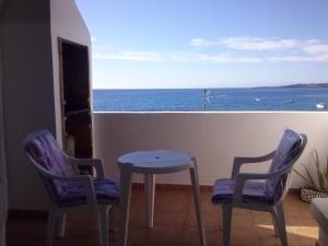 d'une table et de deux chaises sur un balcon donnant sur l'océan. dans l'établissement Casa Chanin, à Punta de Mujeres