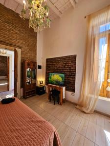 a bedroom with a bed and a tv and a brick wall at El Centurión del Camino Real in Villa Tulumba