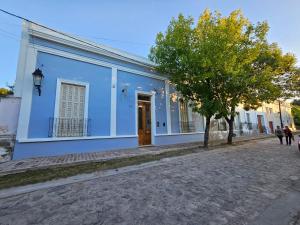 a blue building with a tree in front of it at El Centurión del Camino Real in Villa Tulumba