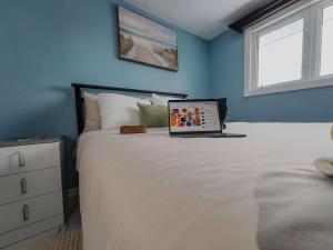 a bedroom with a bed with a laptop on it at Logis des prodiges - Le 777 in Rouyn-Noranda