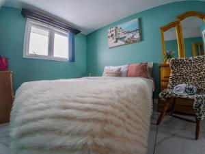 Un dormitorio con una gran cama blanca y una ventana. en Logis des prodiges - Le 777, en Rouyn