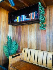 a wooden wall with a bench and a shelf with books at Seaside Cenang in Pantai Cenang