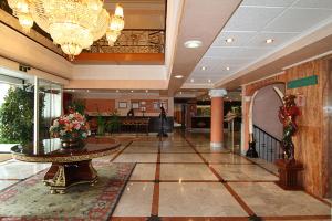 a lobby with a table in the middle of a building at Hotel Begoña Park in Gijón