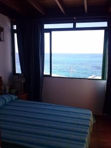 a bedroom with a bed with a view of the ocean at Casa Chanin in Punta Mujeres