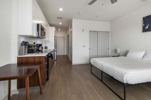 a bedroom with a large bed and a kitchen at Charming Nulu SDO CozySuites 01 in Louisville