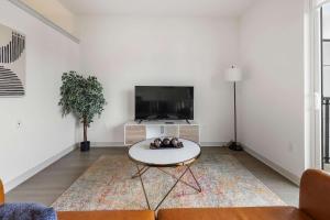 a living room with a tv and a coffee table at Stunning Nulu 1BR CozySuites 10 in Louisville
