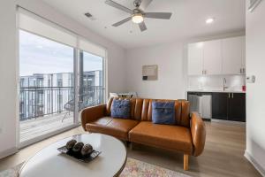 a living room with a couch and a table at Stunning Nulu 1BR CozySuites 10 in Louisville +28 photos