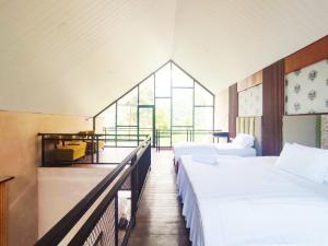 a large room with two beds and a window at Napoleon Hills Tambi Tea Gardens View RedPartner in Kejajar +21 photos