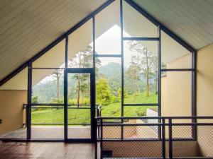 a room with a large window with a view of a mountain at Napoleon Hills Tambi Tea Gardens View RedPartner in Kejajar