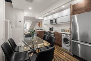 una cucina con un tavolo di vetro e sedie nere di Lower Manhattan 3BR Gem, Perfect for Families a New York
