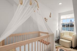 Camera per bambini con culla e sedia di Lower Manhattan 3BR Gem, Perfect for Families a New York