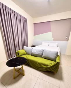 a bedroom with a bed with a green blanket at 玉里步道民宿 in Yuli