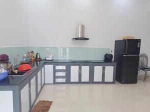 a kitchen with a counter and a black refrigerator at Nhà ở tại Cam Ranh in Thôn Xuan Ninh