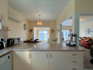 a kitchen with a counter top and a living room at Coleman Comfort Hub - close to City&Air port in Moonah