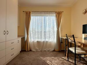 a room with a window with a desk and a table at Coleman Comfort Hub - close to City&Air port in Moonah