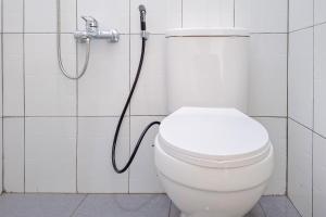 a white toilet in a bathroom with a shower at RedDoorz Syariah Near Alun-Alun Kudus in Kudus