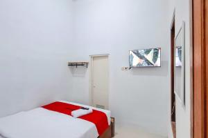a white room with a bed and a mirror at RedDoorz Syariah Near Alun-Alun Kudus in Kudus +10 photos
