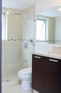 y baño con aseo, ducha y lavamanos. en Charming Two Bedroom with River view, en San José