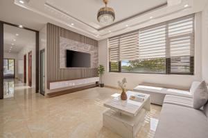 a living room with a couch and a tv at Hùng Villa 5br Full Ac Quite -Rooftop Pool- Bida- New in Da Nang