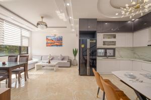 a kitchen and living room with a table and chairs at Hùng Villa 5br Full Ac Quite -Rooftop Pool- Bida- New in Da Nang