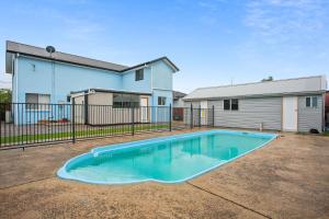 a swimming pool in a yard in front of a house at Coastal Blue in Windang