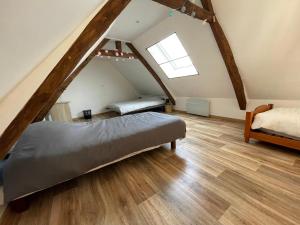 a attic bedroom with two beds and a window at Gite La Maison Blanche in Drouvin-les-Marais