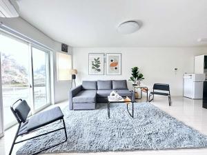 Modern designed property 15 mins from Kumamoto station by Restavio في Ozu: غرفة معيشة مع أريكة وطاولة