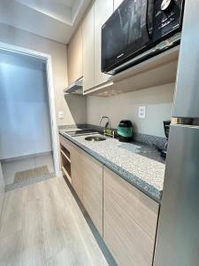 una cocina con fregadero y microondas en Studio in Vila Mariana, en São Paulo