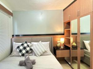 a bedroom with a bed with a large headboard at Two Bedroom at One Spatial Iloilo in Iloilo City +6 photos