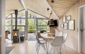 a dining room with a table and a fireplace at Holiday Home Røllikevej Tranekær V in Skattebølle
