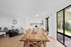 Un comedor y una sala de estar con mesa y sillas. en Bailey's Beach House, en East Ballina