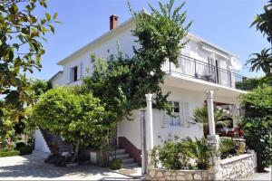 a white house with trees in front of it at Vinka Apartment in Sreser