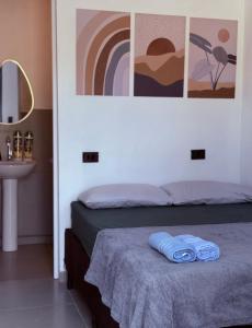 a bedroom with a bed with two blue towels on it at Mini Suite - Pousada Lemon com Cozinha - Sesc Bertioga - Ar Condicionado e Frigobar in Bertioga +36 photos