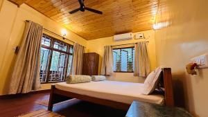 um quarto com uma cama grande em frente a uma janela em Tamarind Tree Masinagudi em Masinagudi