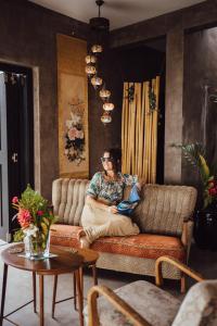 a woman sitting on a couch in a living room at South Pacific Memories in Port Vila