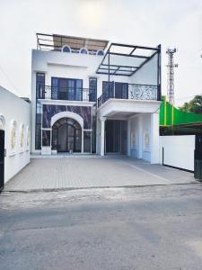 a large white building with a large parking lot at YUTAKA INN Nabila Juanda Airport Sidoarjo in Semampir
