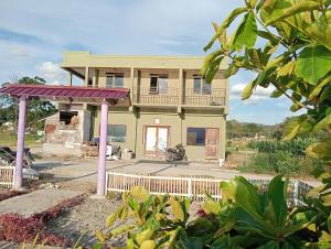 a house with a balcony and a motorcycle in front of it at Arthuro homestay in Si Antar