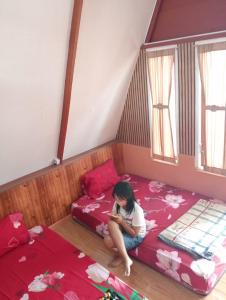 a girl sitting on a bed in a room at Arthuro homestay in Si Antar +20 photos