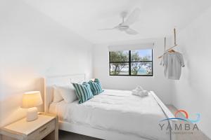 une chambre blanche avec un lit et une fenêtre dans l'établissement Stella LJHooker Yamba, à Brooms Head