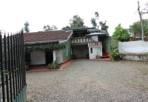 a house with a fence in front of it at Sumanagiri Holiday Home in Bandarawela