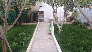 a wooden walkway in a yard with trees and a building at Ginjals 67 in Almargem do Bispo