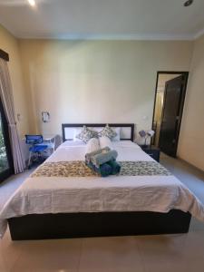 a bedroom with a bed with two stuffed animals on it at The Green Harmony Villa Homestay in Sanur