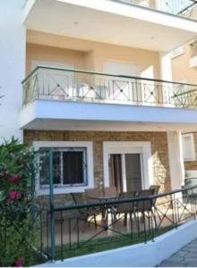 a balcony with a table and chairs in front of a building at Nikoleta Summer Glow in Kriopigi