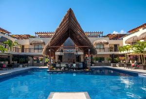 einen Pool mit einem Pavillon vor einem Gebäude in der Unterkunft Awesome apartment at Aldea Thai Beachfront in Playa del Carmen
